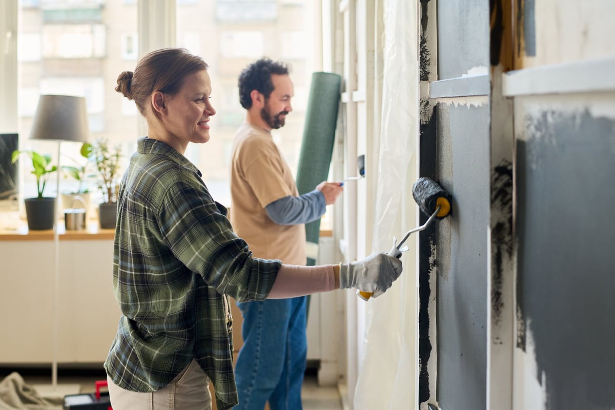 Woman painting living room wall during home improvement